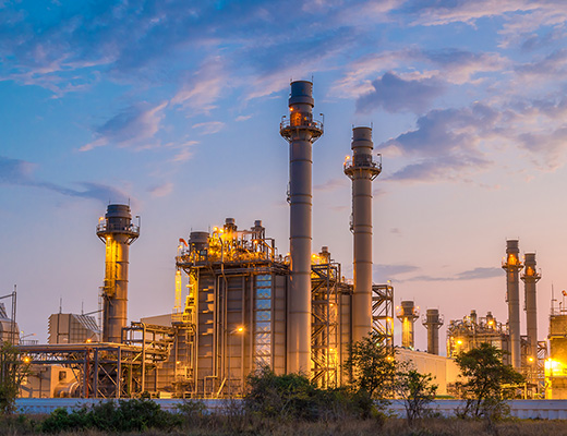 Oil and gas processing plant lit at dusk
