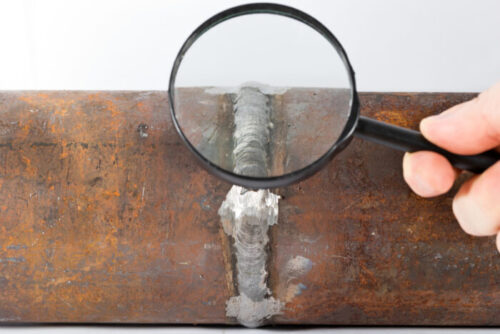 Visual inspection of a weld with magnifying glass